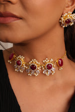 Load image into Gallery viewer, Close-up of a person wearing gold jewelry with red stones
