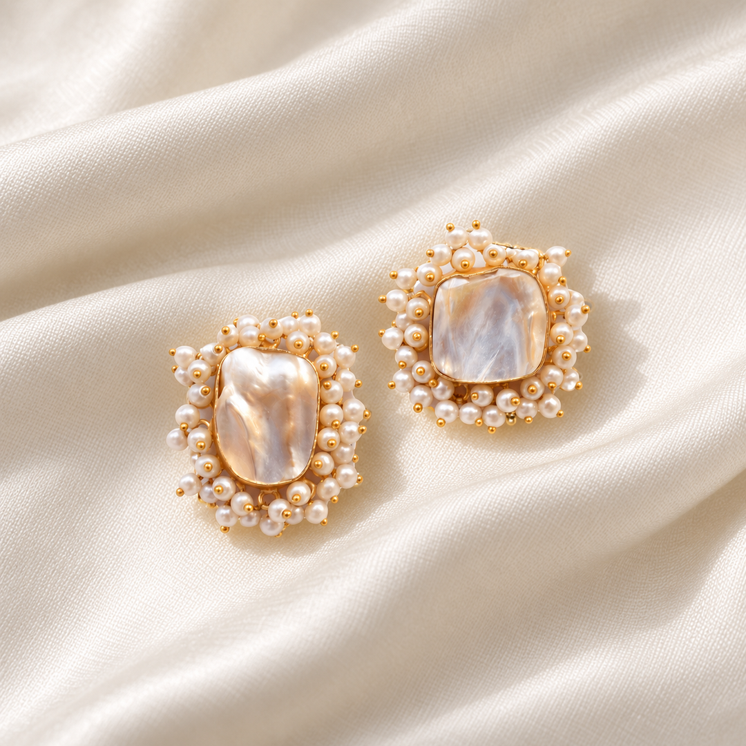 Baroque pearl cluster stud earrings arranged on ivory silk