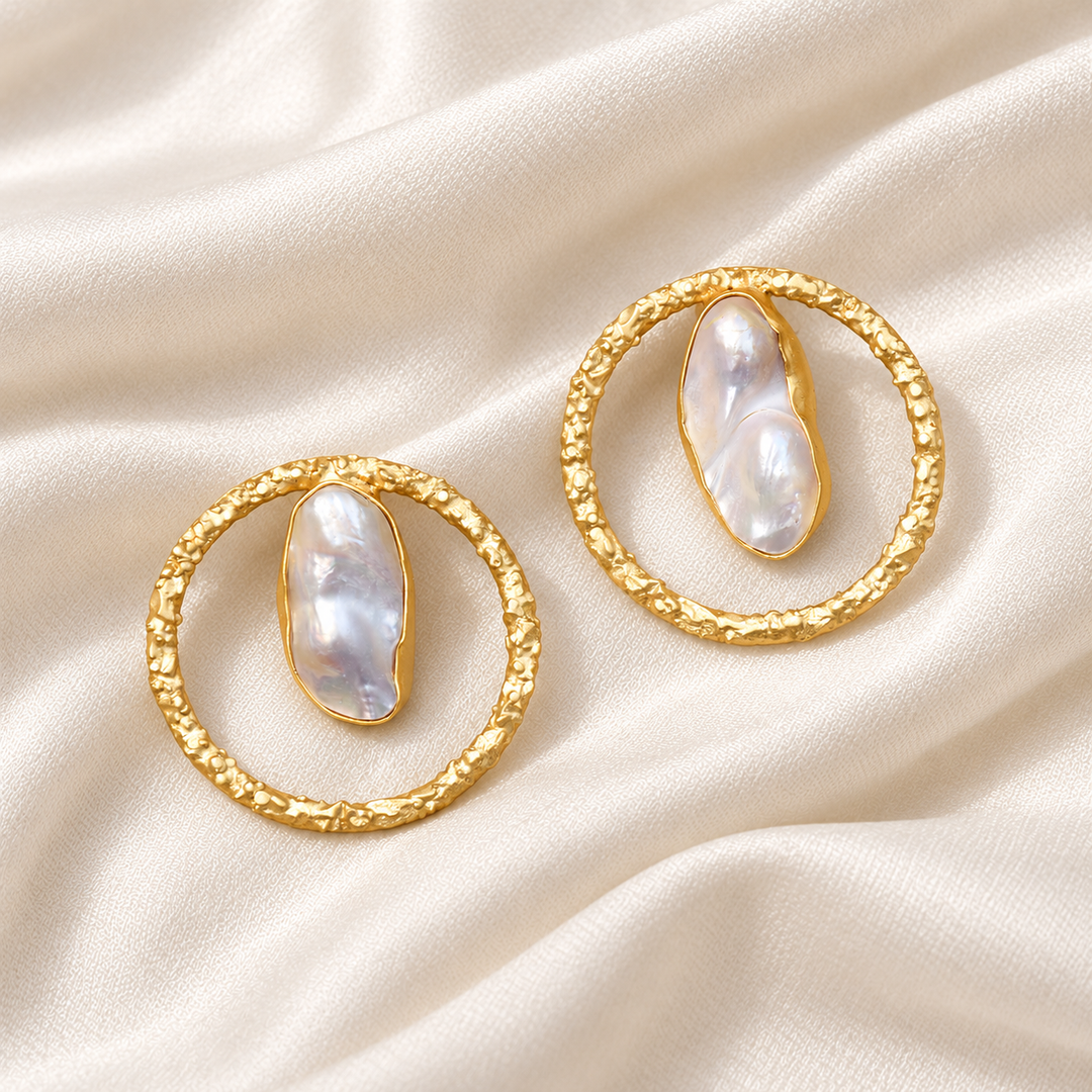 Baroque pearl open circle stud earrings arranged on ivory silk