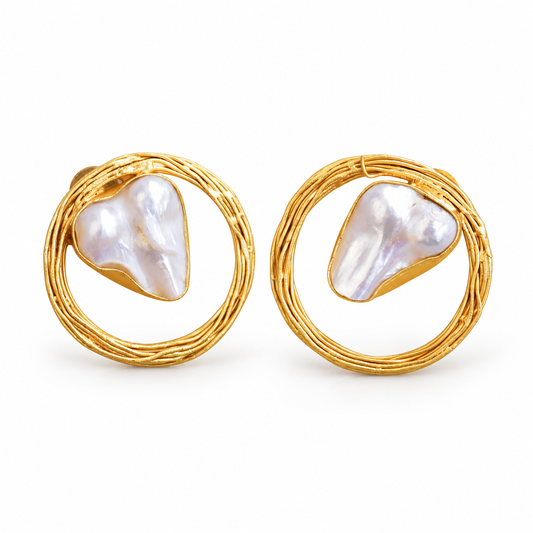 Baroque pearl stud earrings inside woven gold-tone circle frames on white